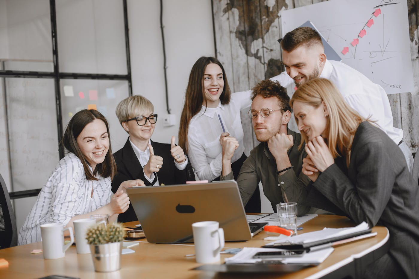 A business team gathered around a laptop during a planning discussion.